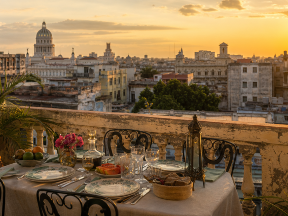 A private concierge in Cuba arranging a rooftop paladar table above Havana at sunset